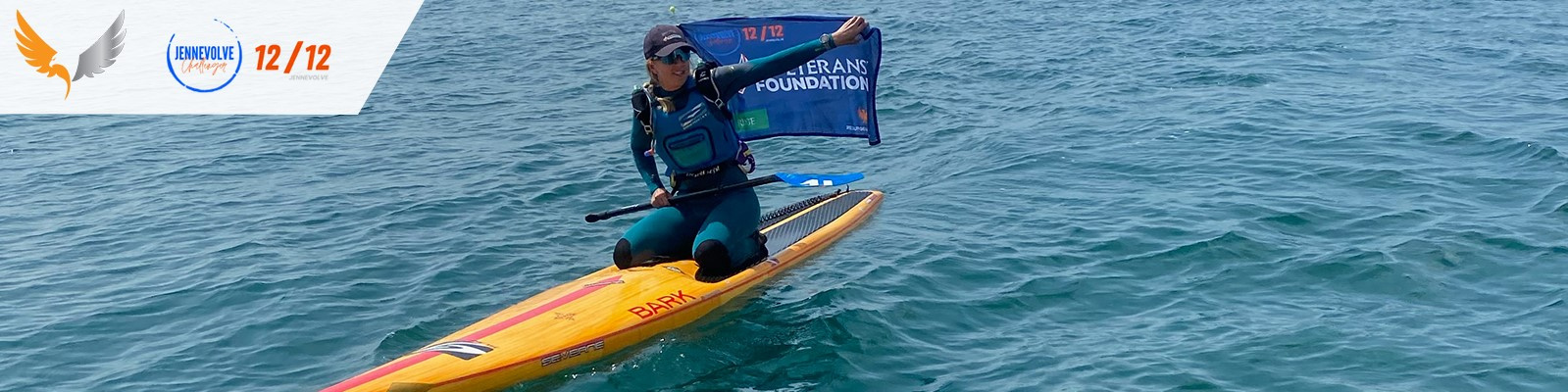 Jennifer Price on a paddle board in the English Channel waving a Veterans' Foundation flag
