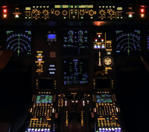 Aeroplane cockpit at night, showing the dials and flight instruments lit up